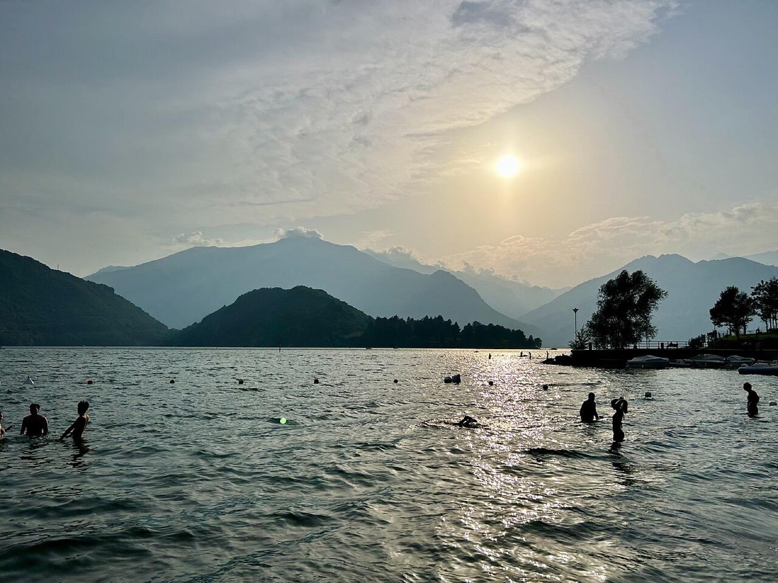 Swimmers in Lake Como at sunset