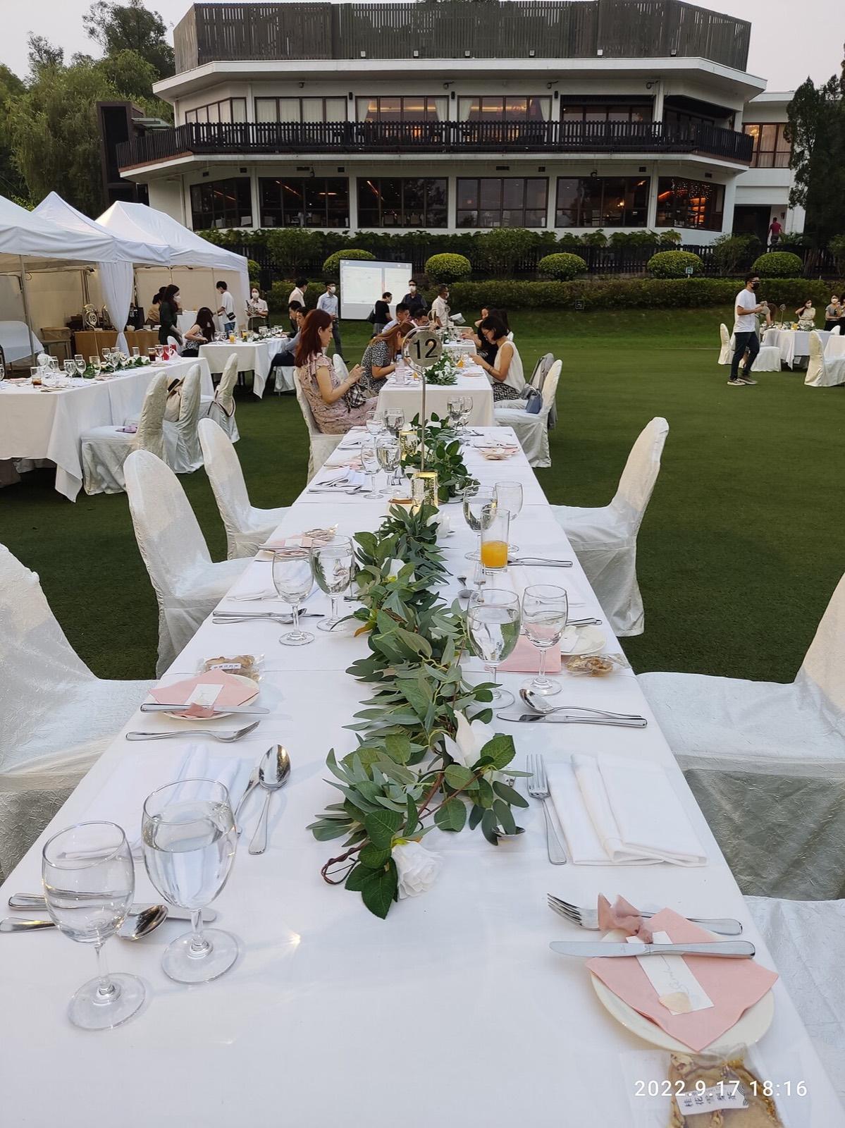 A long outdoor table with a garland of greenery